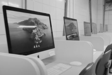 Fotografia dos MacBooks no laboratório de comunicação na ilha de edição LABCOM